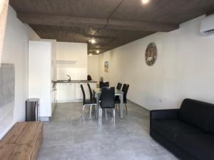 a living room with a table and chairs and a couch at Seafront place Spinola StJulians in St. Julianʼs +13 photos