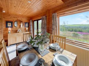 a dining room with a table and a large window at Bengairn in Ringford