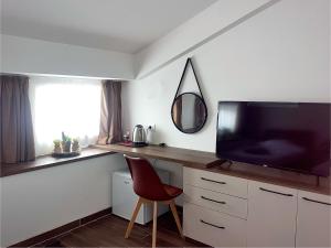 a room with a desk with a television and a chair at VP Apartments Bitola in Bitola