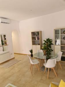 ein Esszimmer mit einem Glastisch und weißen Stühlen in der Unterkunft Amplio apartamento 2 Dormitorios 4Pax Decoración moderna in Madrid