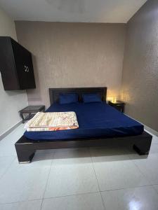 a bedroom with a bed with blue sheets and blue pillows at Bite of Life Cafe and Resort in Dehradun