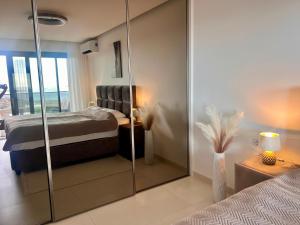 a bedroom with a bed and a glass wall at Primosten Resort Sunhill Deluxe Apartment Laura in Primošten +26 photos