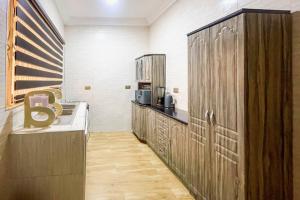 a kitchen with wooden cabinets and a large letter b at Caroline Cozy Holiday Stay in Ashalebotwe