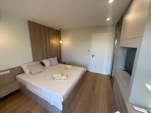a bedroom with a bed with two towels on it at Villa Bellavista, rooftop, jakuzzi, infinity pool in Sukošan