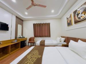 a hotel room with two beds and a television at Hotel Royale Heritage in Ujjain +16 photos