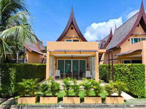 a house with palm trees in front of it at Blue Haven Bay Villas and Resort Apartments in Ko Chang