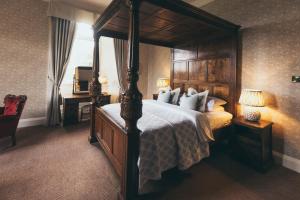 a bedroom with a large bed with a wooden canopy at Rowton Castle in Shrewsbury +79 photos