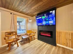 a living room with a fireplace and a tv at Remodelled cabin! great location! in Sevierville