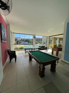 a room with two pool tables and a large window at Apartamento aldeia das águas in Barra do Piraí
