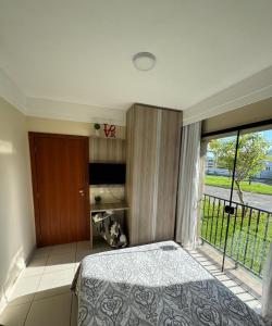a bedroom with a bed and a large window at Apartamento aldeia das águas in Barra do Piraí