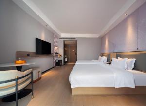 Giường trong phòng chung tại 柏曼Borrman国际酒店 ZhangJiaJie National Forest Park East Gate Branch