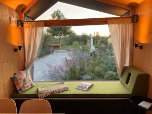 a window seat in a tiny house looking out at a garden at Draußendrin Cabin im schönen Altmühltal in Kelheim