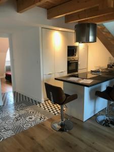 a kitchen with a counter and chairs in a room at Hyper centre 50m Mer in Douarnenez