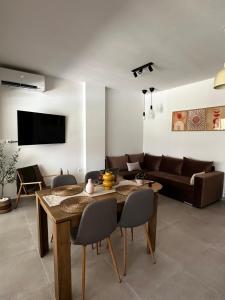 a living room with a table and a couch at Aura Luxury Home in Pogoniá