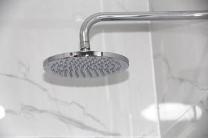 a shower with a shower head in a bathroom at Mysore House - Nanyuki in Nanyuki