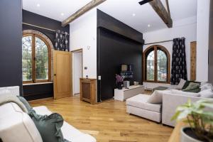 Una sala de estar con muebles blancos y paredes negras. en The Chapel - Telford, en Telford