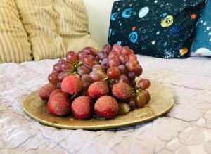 a plate of strawberries and grapes on a bed at Doc Azenith Presidential Suite - Cebu Mactan Airport Condo - Sandria Nicole in Pajak +2 photos