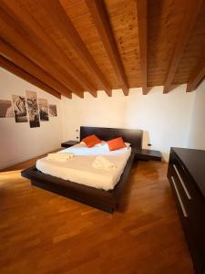 Una cama grande en una habitación con techo de madera. en La Meridiana, en Lonato