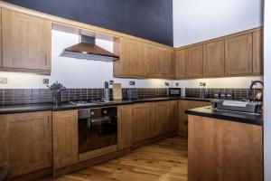 a kitchen with wooden cabinets and black counter tops at The Chapel - Telford in Telford