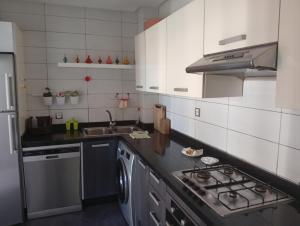 une cuisine avec un évier et une cuisinière four supérieur dans l'établissement luxu appart siesta beach resort, à Mohammedia