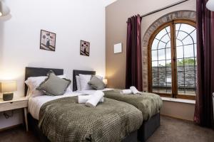 two beds in a bedroom with a window at The Chapel - Telford in Telford