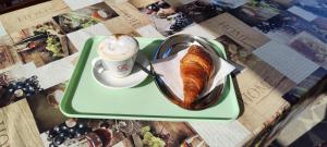 a green tray with a cup of coffee and a loaf of bread at Casa naanì Mughetto in San Colombano