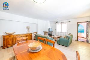 a living room with a wooden table and chairs at Apartamentos Ibiza Casa Azahar in Alcossebre