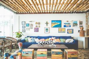 a living room with a blue couch and a dog statue at Pousada a Capela in Arembepe