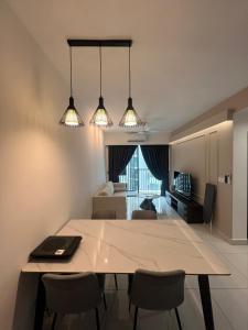 a kitchen and living room with a table and chairs at Edumetro A07 3Bedroom Subang Sunway By MICASA GROUP in Subang Jaya
