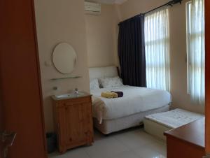 a bedroom with a bed with a mirror and a sink at G10 Guest House Near Asia Afrika Bandung in Bandung