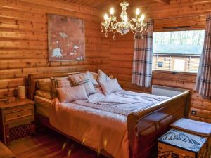 a bedroom with a bed in a log cabin at Kenwick Lodge - Uk37416 in Legbourne +4 photos