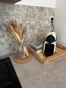 a kitchen counter with a vase with wooden utensils at Appartement Garibaldi cosy - bien placé & tout confort in Saint-Étienne +7 photos