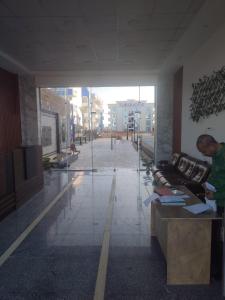 a man standing at a desk in a lobby at Luxuries Studios and apartments in Oasis Marina ,Hurghada in Hurghada