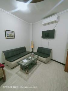 a living room with two green couches and a table at Peace Hotel Fizagat, Swat in Swat