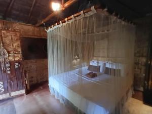 a bedroom with a bed with white curtains at Herbs Guest House and Restaurant near the Sea in Moalboal
