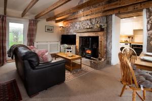a living room with a couch and a fireplace at The Bothy, Press Mains Farm Cottages in Eyemouth