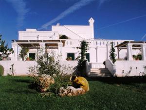 a person in the grass in front of a white house at B&B Lamascopone in Fasano