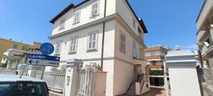 una casa bianca con un cartello stradale davanti di Villa Ginevra ad Anzio