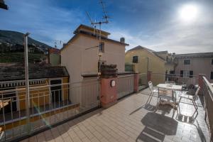 a patio with a table and chairs on a balcony at Ca' de Nina, nel cuore di Moneglia a pochi passi dal Mare in Moneglia