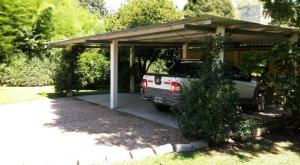 a carport with a truck parked in a garage at LO de JIMENA in Los Cardales