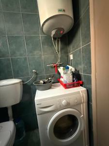 baño pequeño con lavadora y lámpara en Studio 75 meters to the sea, en Rafailovici 3 fotos más