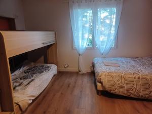 a bedroom with a bed and a window with blue curtains at Maison de campagne à Château-Chervix in Château-Chervix