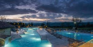 a large swimming pool at night with lights at Antico casale per relax e natura in Casiano