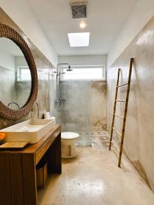 チャングーにあるVilla Novaの洗面台、トイレ、鏡のあるバスルーム