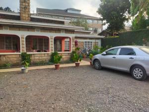 a car parked in front of a house at Rachel's Garden in Meru