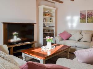 a living room with two couches and a television at West House Farm in Filey