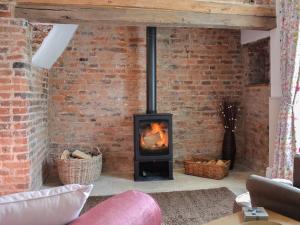 a brick wall with a wood stove in a living room at West House Farm in Filey