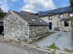 an old stone house with a stone wall at Four à pain in Sprimont