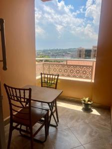 Una mesa y sillas en un balcón con vista. en Ruth Flora Apartment, en Kampala 2 fotos más