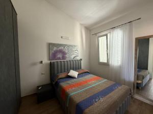 a bedroom with a bed with a colorful blanket at Il Frutteto Barbarossa in Porto Azzurro